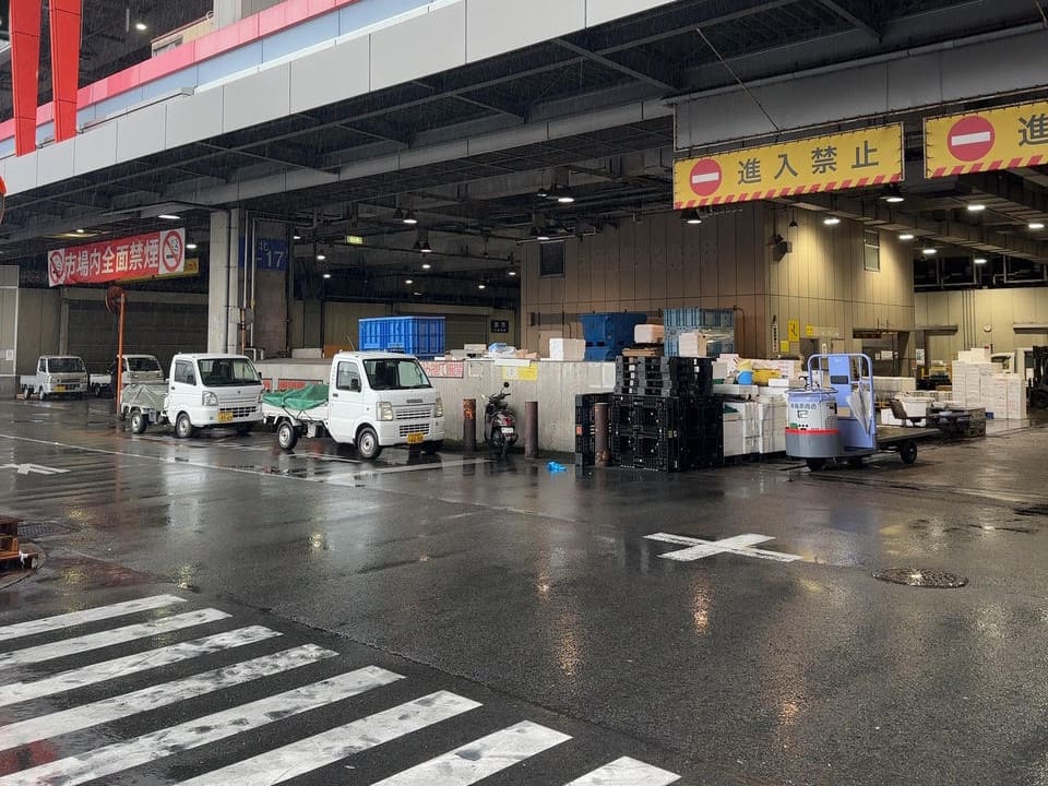 早朝の市場で荷待ちする軽貨物車