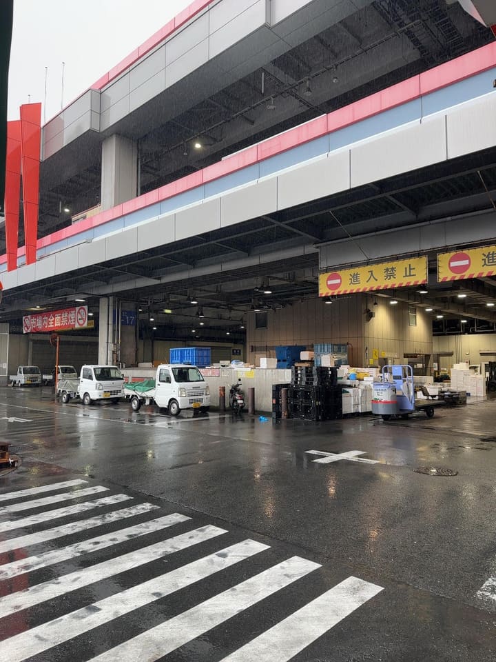 早朝の市場に停まる軽貨物車